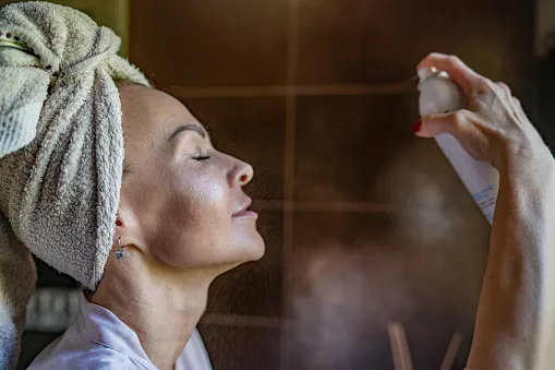 Woman after bath using spray for face Woman after bath using spray for face