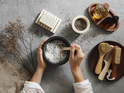 Woman making homemade bath salt with lavender Woman making homemade bath salt with lavender