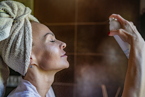 Woman after bath using spray for face